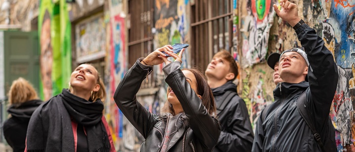 Klassenfahrt in Berlin - Schüler*innen fotografieren Streetart in Berlin-Mitte.