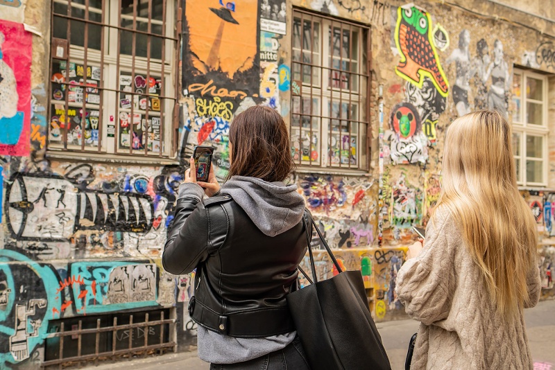 Zwei Schülerinnen fotografieren Streetart in Berlin.