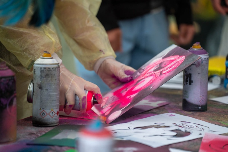 SchülerInnen sprühen mit Farbdose Graffiti.