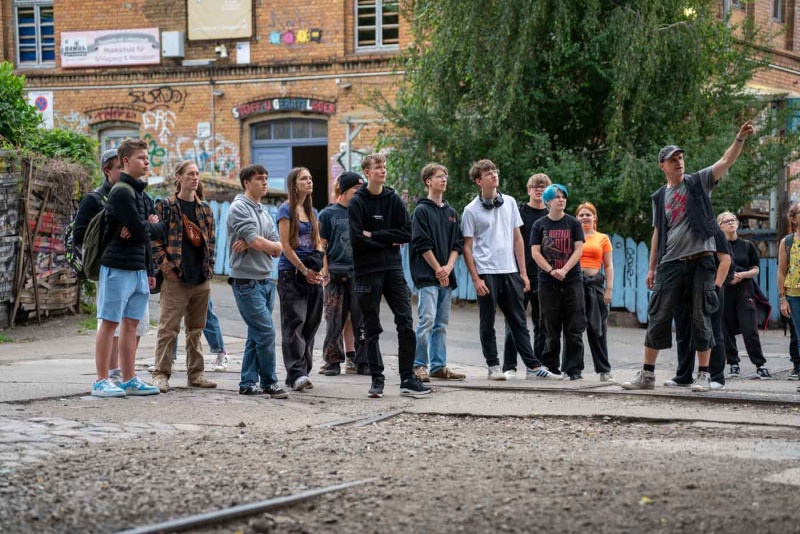 Guide macht mit einer Schulklasse eine Stadtführung.