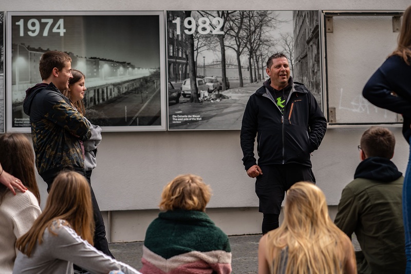 Ein DDR-Zeitzeuge erzählt vor einer Schulklasse in der Bernauer Straße in Berlin.